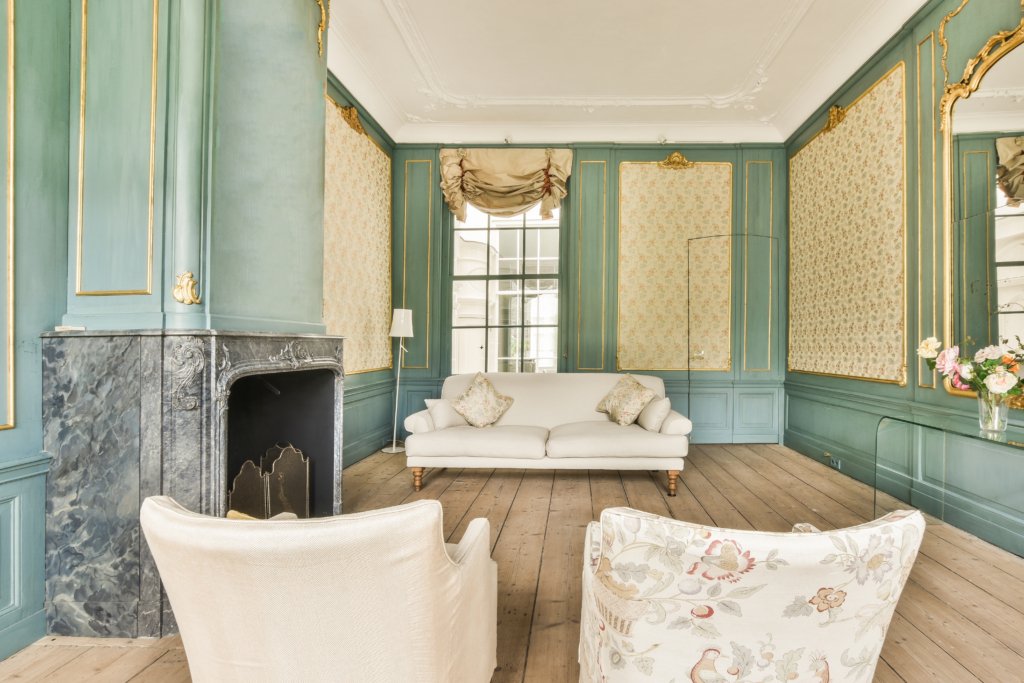 Stylish luxury home interior design of cozy living room with burning fireplace and comfy sofa in daylight